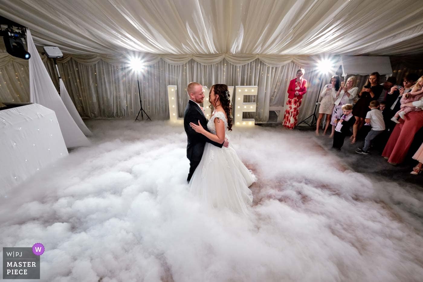 Bride and groom dancing on the clouds during their first dance
