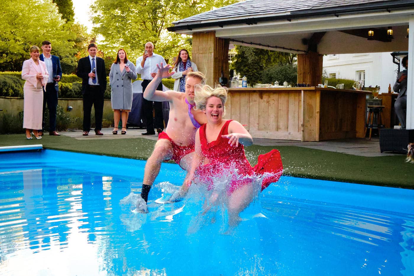 Bride and groom jumping into pool at the end of their wedding day