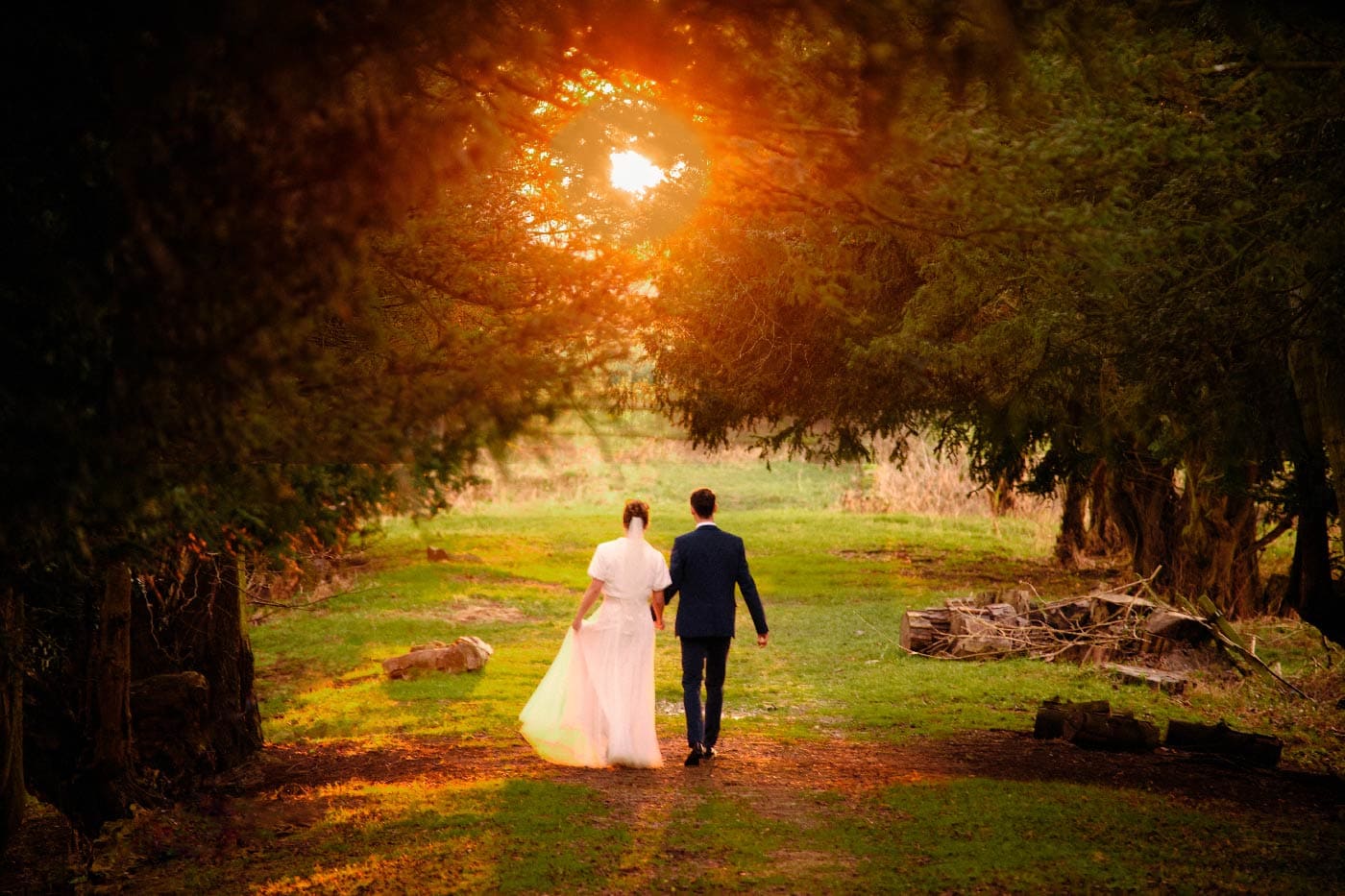 Bride and groom walking together during golden hour at Ettington Park
