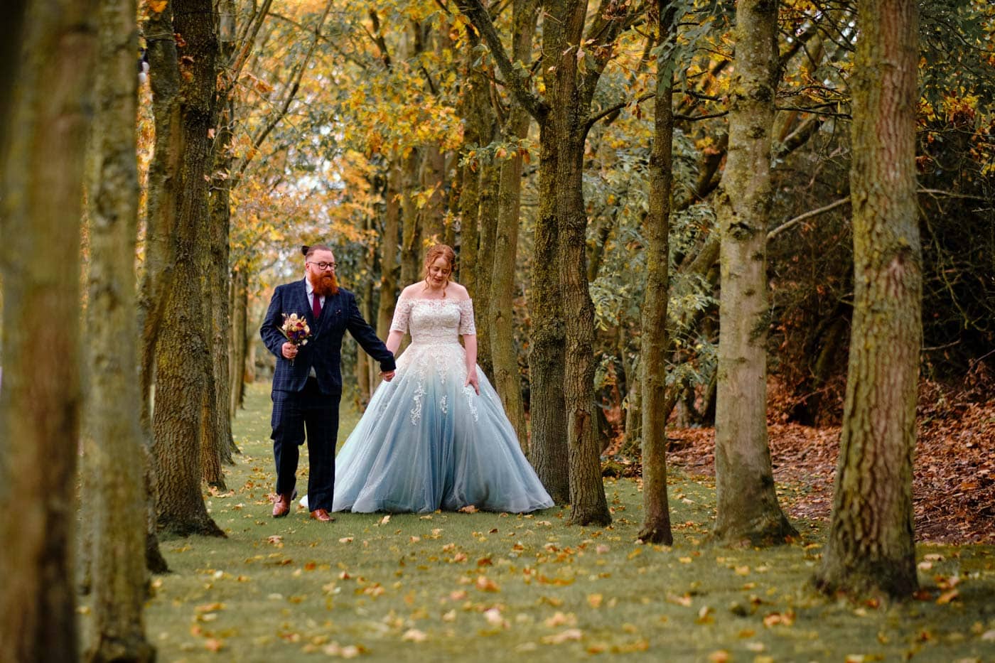 Bride and groom walking in grounds of Shustoke Barn by Shustoke Barn wedding photographer Clive Blair